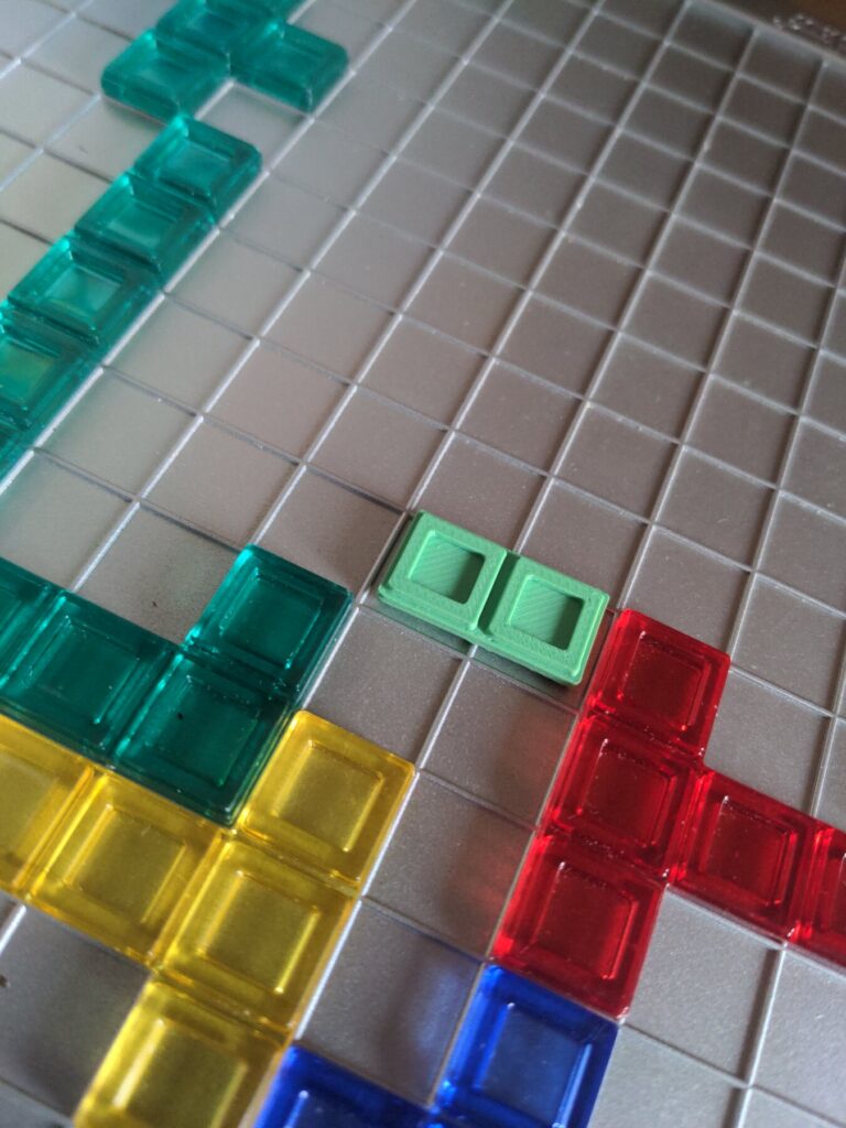 Pièce verte de Blokus refabriquée en impression 3D sur le plateau