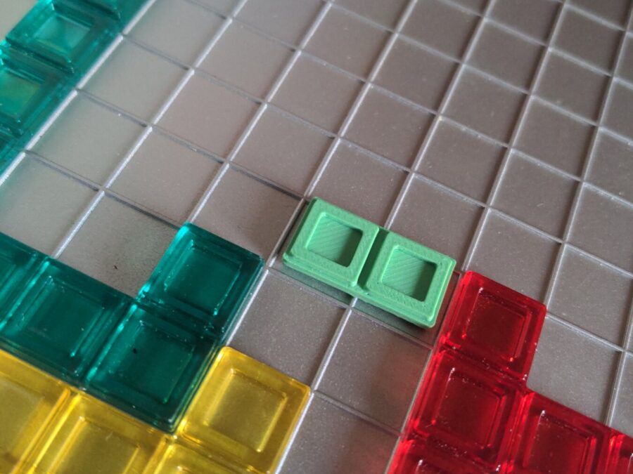 Pièce verte de Blokus refabriquée en impression 3D sur le plateau